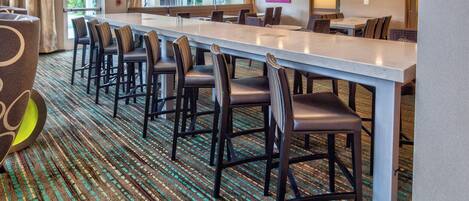 A conference room with a long table and chairs, carpeted floor, and a view through the window.