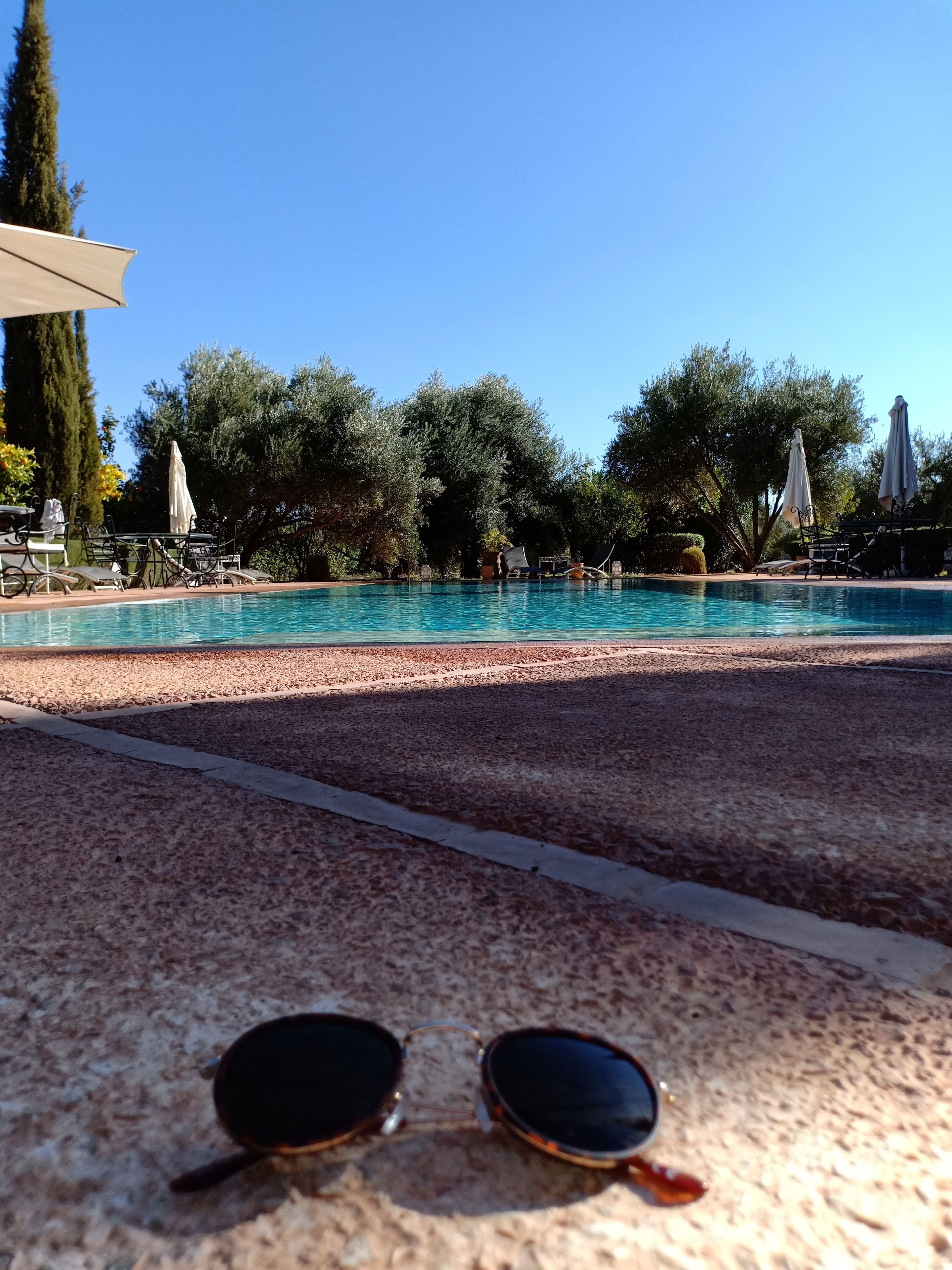 A pool area with lounge chairs and umbrellas.