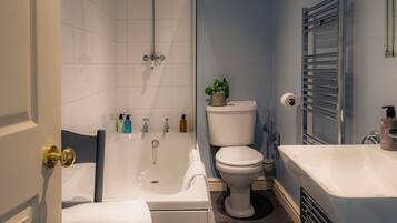 A bathroom with a bathtub, toilet, and sink.