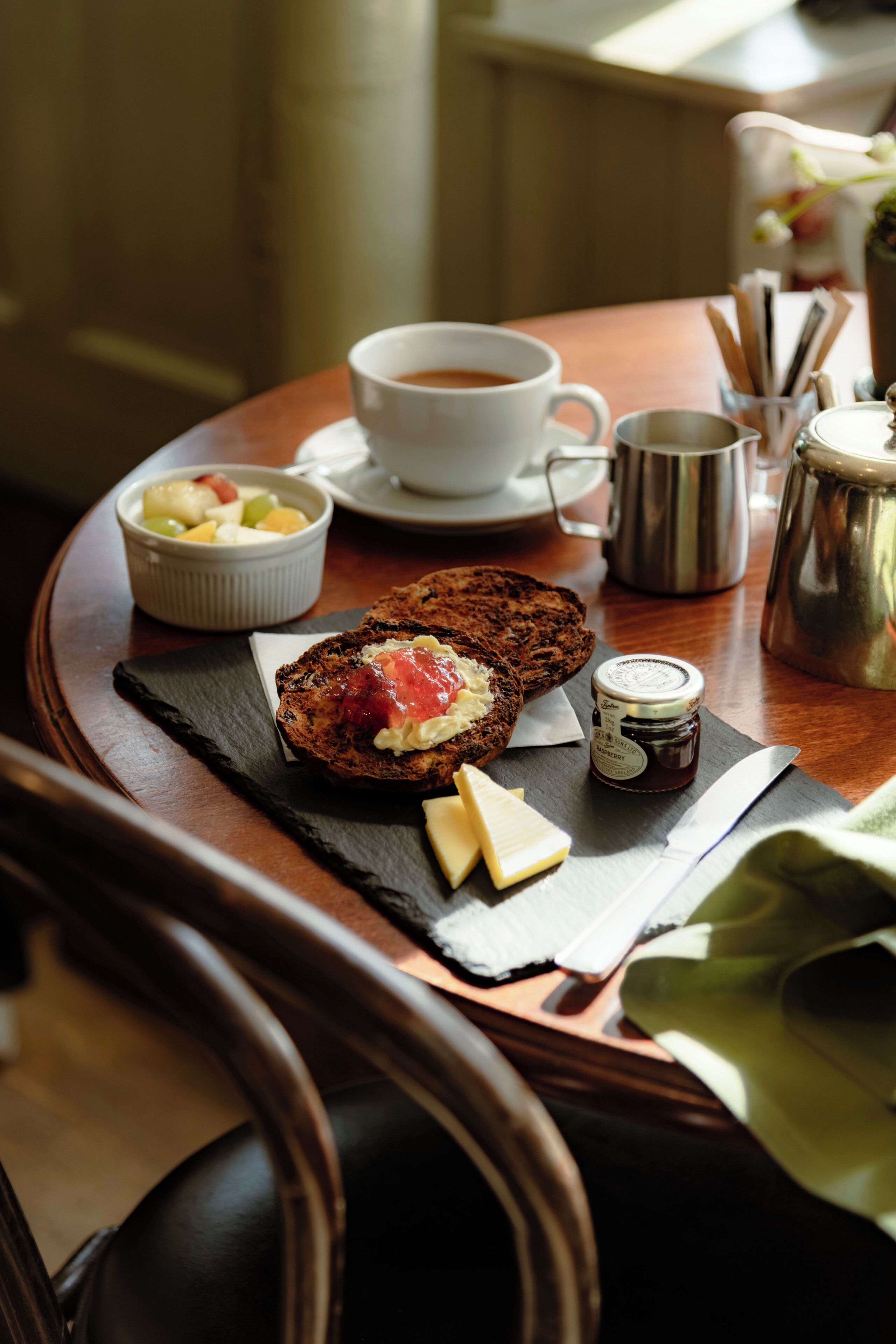A breakfast tray with toast, jam, butter, and a cup of coffee.