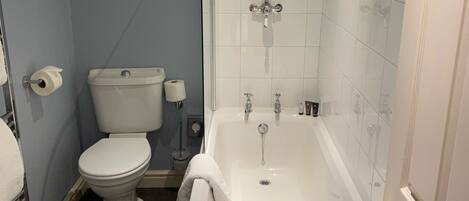 Un baño con inodoro, bañera y ducha.