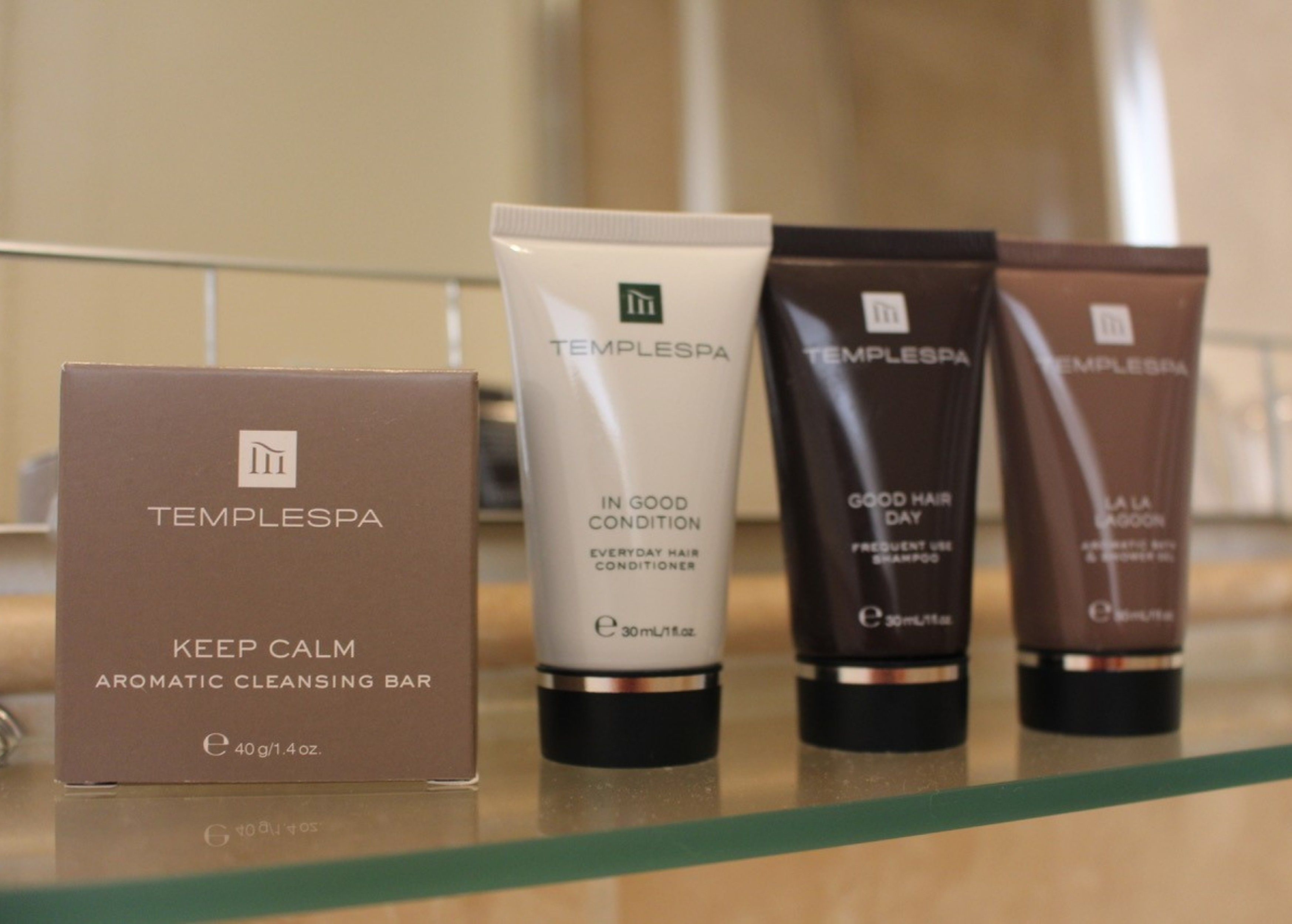 A row of TempleSpa products on a glass shelf.