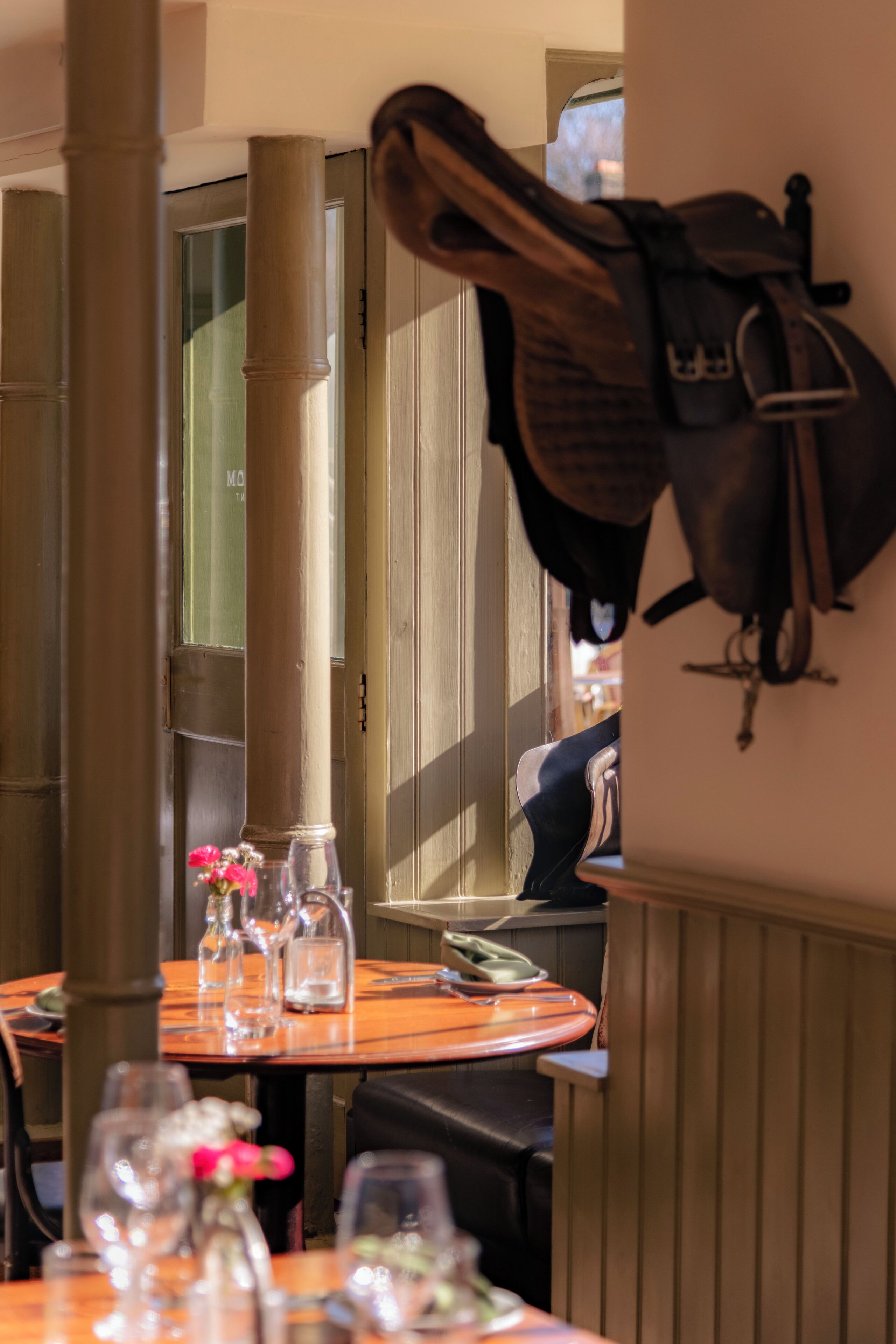 A dining area with a wooden table, chairs, and a wall-mounted coat rack.
