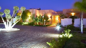 A modern building with a paved driveway and landscaped garden. - Villa Jardins d'Isa (Marrakech)