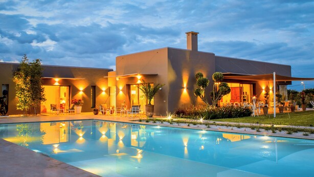 A modern hotel with a swimming pool, outdoor seating, and well-lit pathways. - Villa Jardins d'Isa (Marrakech)