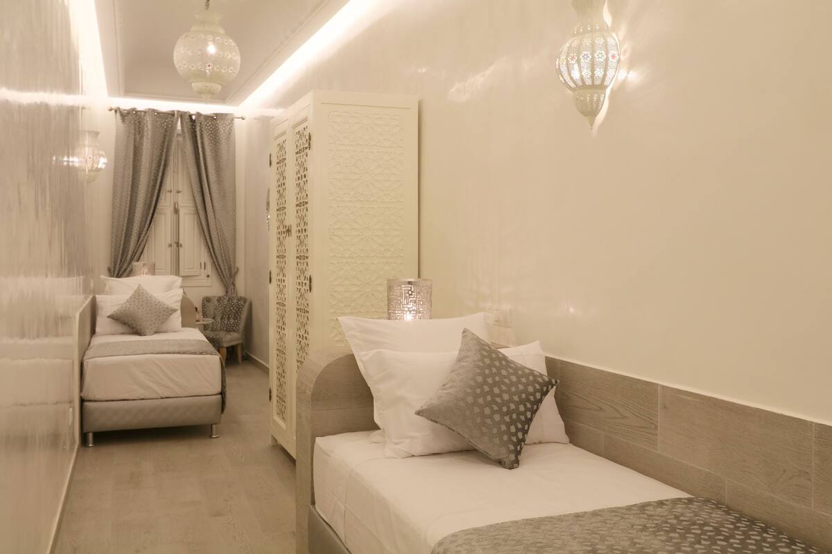 Une chambre à coucher avec un lit, une chaise et une table de chevet.