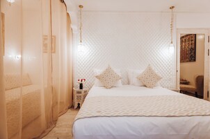 Un dormitorio con una cama grande, una mesita de noche y una silla.