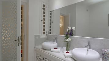 A bathroom with two sinks, a large mirror, and a decorative door.