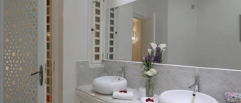 A bathroom with two sinks, a large mirror, and a decorative door.