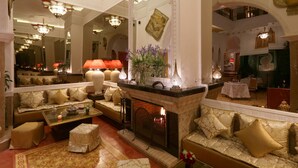 A luxurious lobby with a fireplace, seating areas, and ornate lighting fixtures.