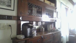 A kitchen with wooden cabinets, a coffee maker, and a sink.