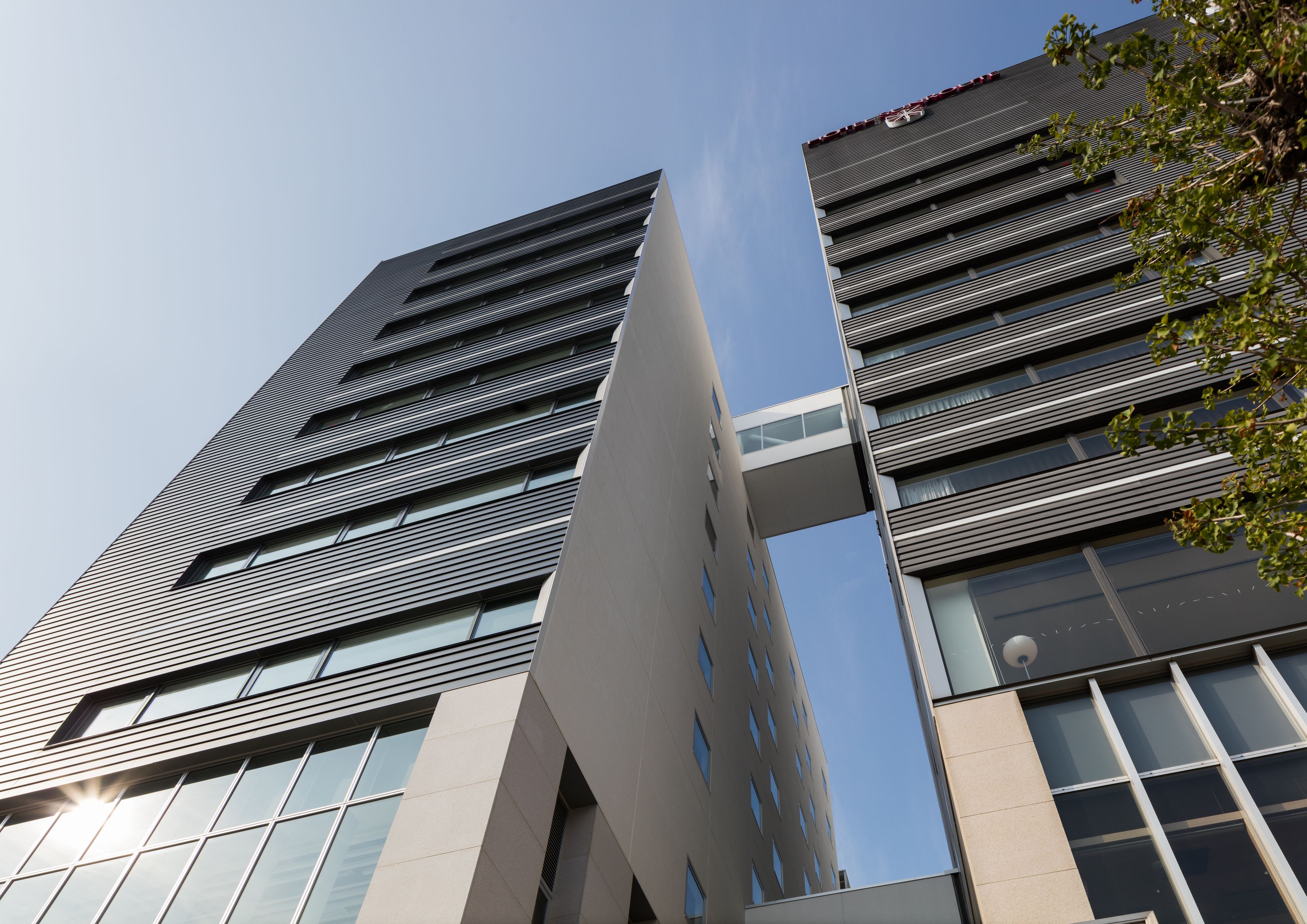 A modern building with a unique architectural design featuring two symmetrical towers connected by a central structure.