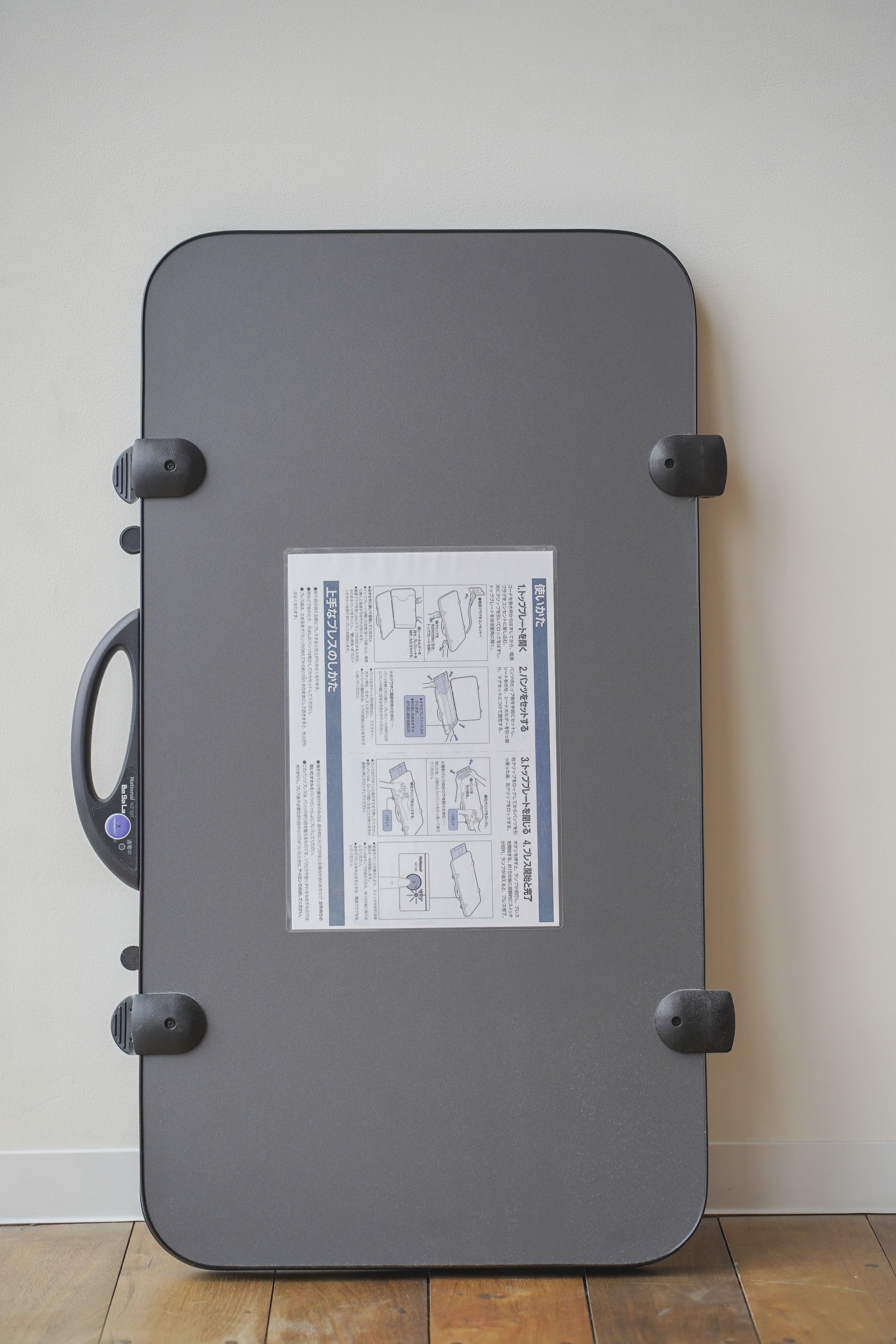 A grey suitcase with a sticker containing text and diagrams.