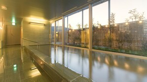 A modern indoor pool area with glass walls, a metal handrail, and a view of the outside. - Hotel Sunroute Tokushima (Tokushima)