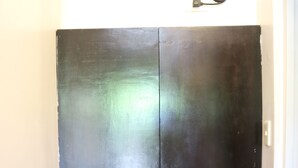 A black wardrobe with two doors and a small window at the top. - Giecel Pension (El Nido)