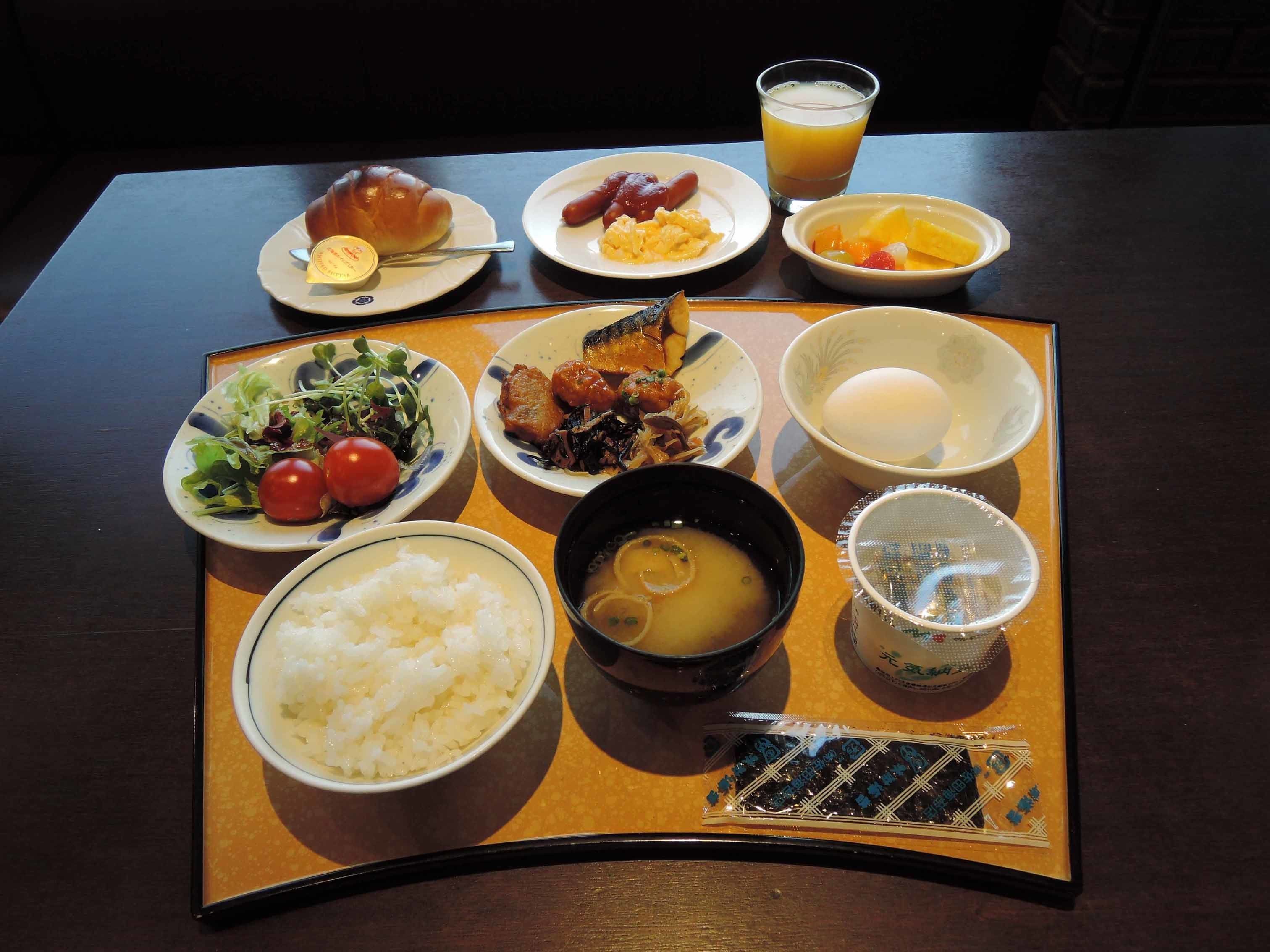 A tray with various Japanese dishes including rice, soup, and a selection of side dishes.