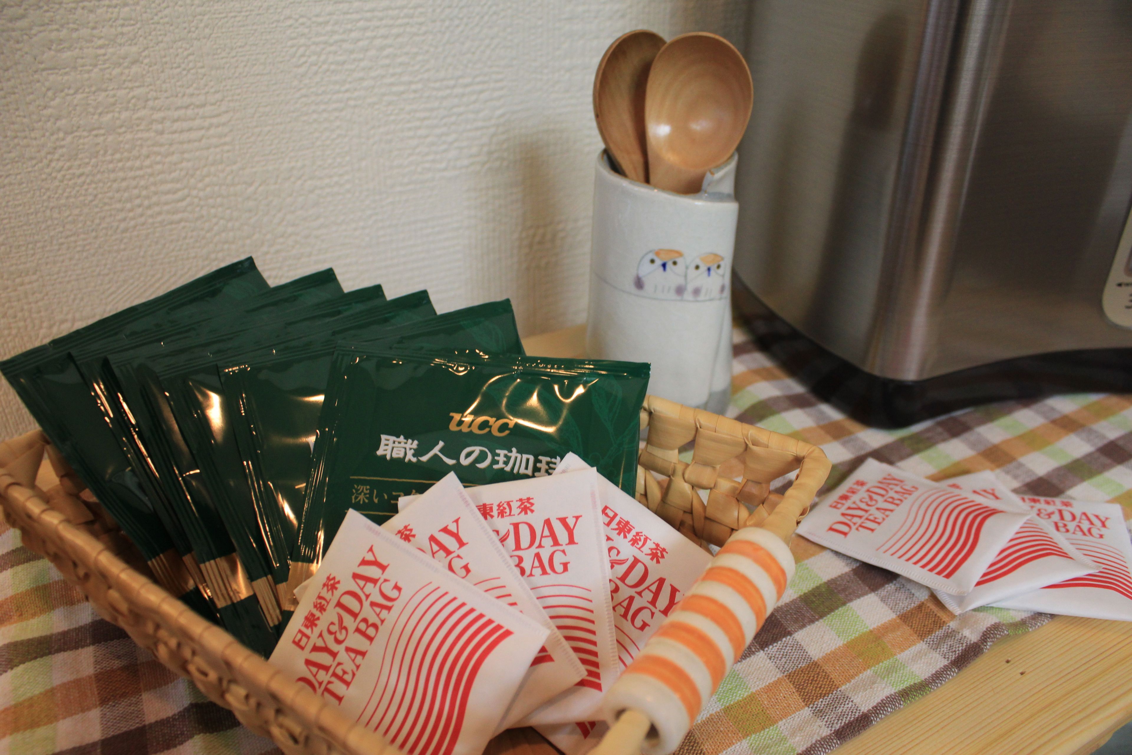 A tray with tea bags and a woven basket on a checkered tablecloth.
