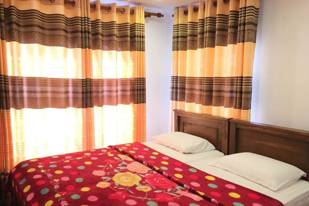 A room with a bed, curtains, and a wooden headboard.