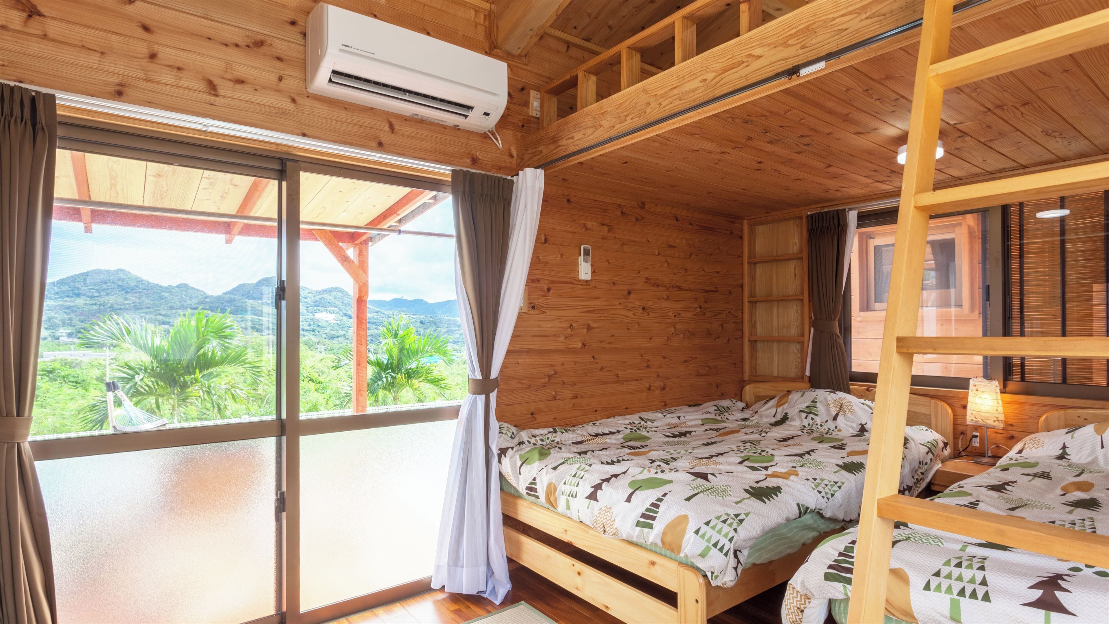 A wooden cabin with a bed, a window with curtains, and an air conditioning unit.