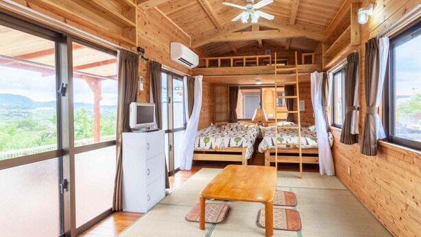 A wooden cabin with two bunk beds, a dining table, and a TV. - Motobu Ikoi no Yado Yamachan (Motobu)