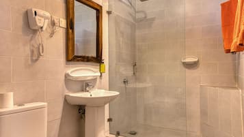 Un baño con inodoro, lavamanos, espejo y ducha.