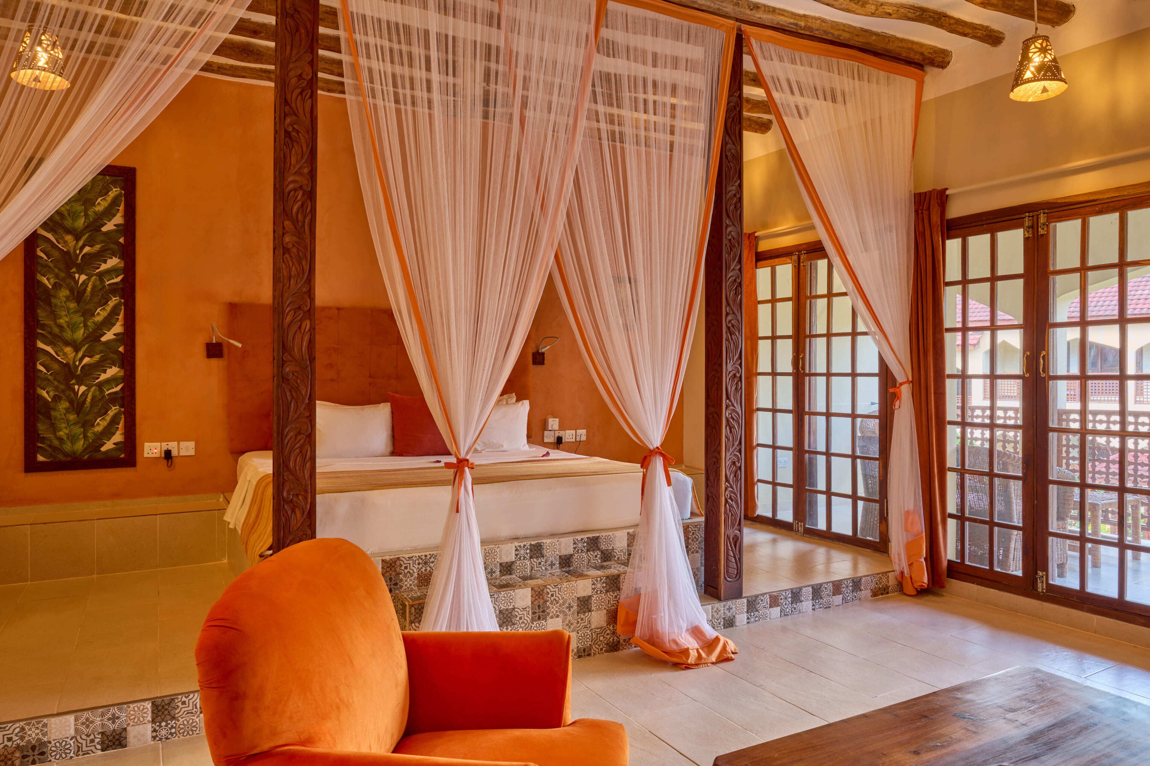 A room with a bed, a chair, and a view through a large window.