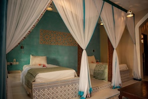 A room with a bed, a bench, and a decorative wall panel. - Kendwa Rocks Beach Hotel (Kendwa)