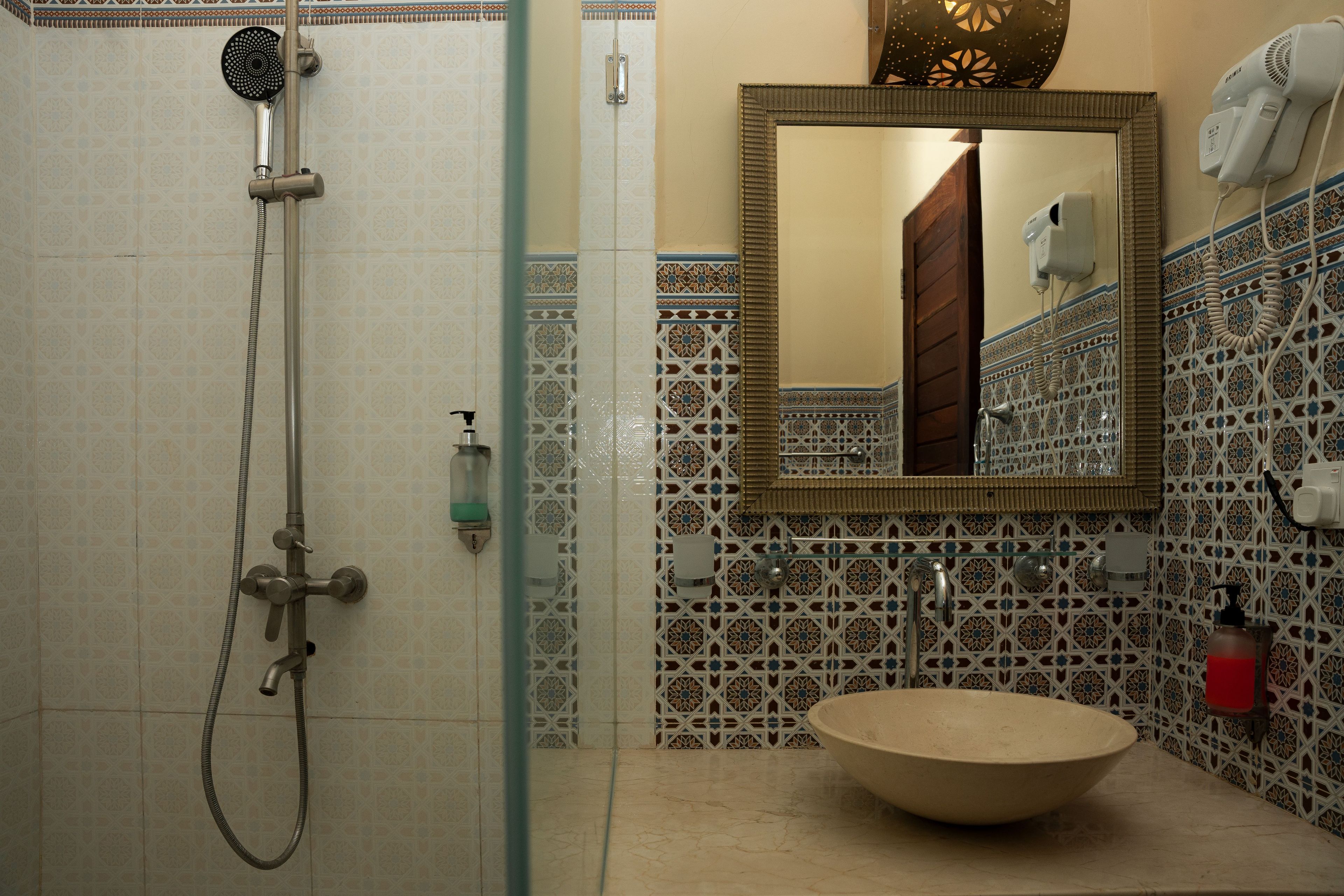 A bathroom with a shower, a sink, and a mirror.