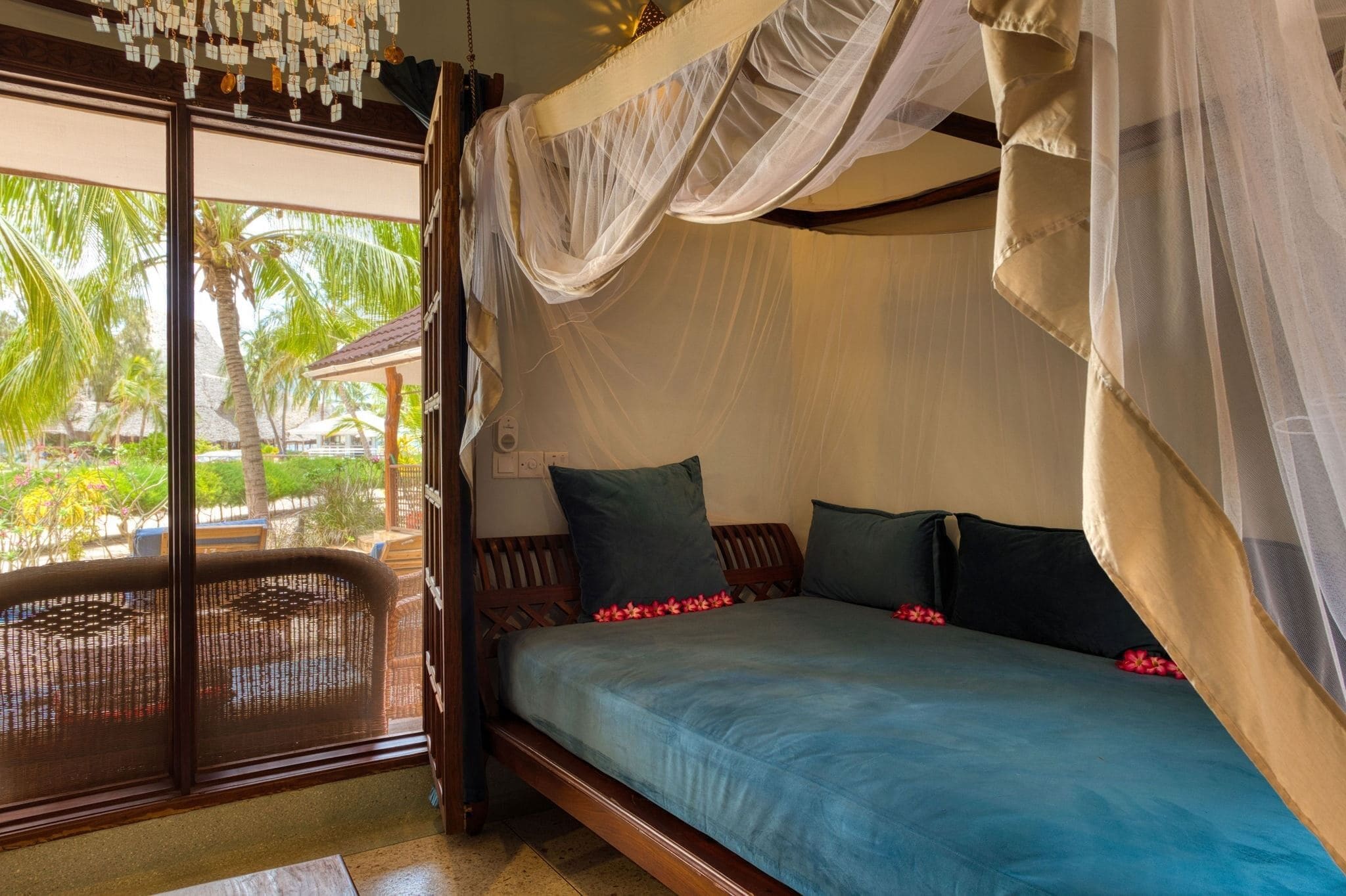 Una habitación con cama, ventana y vista a palmeras.
