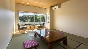 A modern room with a wooden ceiling, tatami mats, a wooden table, and a view of greenery outside. - Ikijimaso (Iki)