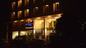 Un hôtel avec une enseigne bien visible sur le devant, de nombreuses fenêtres et une entrée bien éclairée.