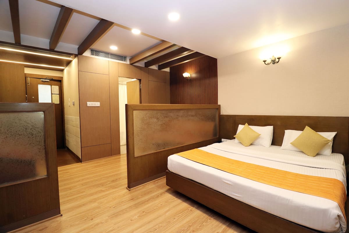 A hotel room with a wooden bed, a wooden wardrobe, and a wooden ceiling with exposed beams.