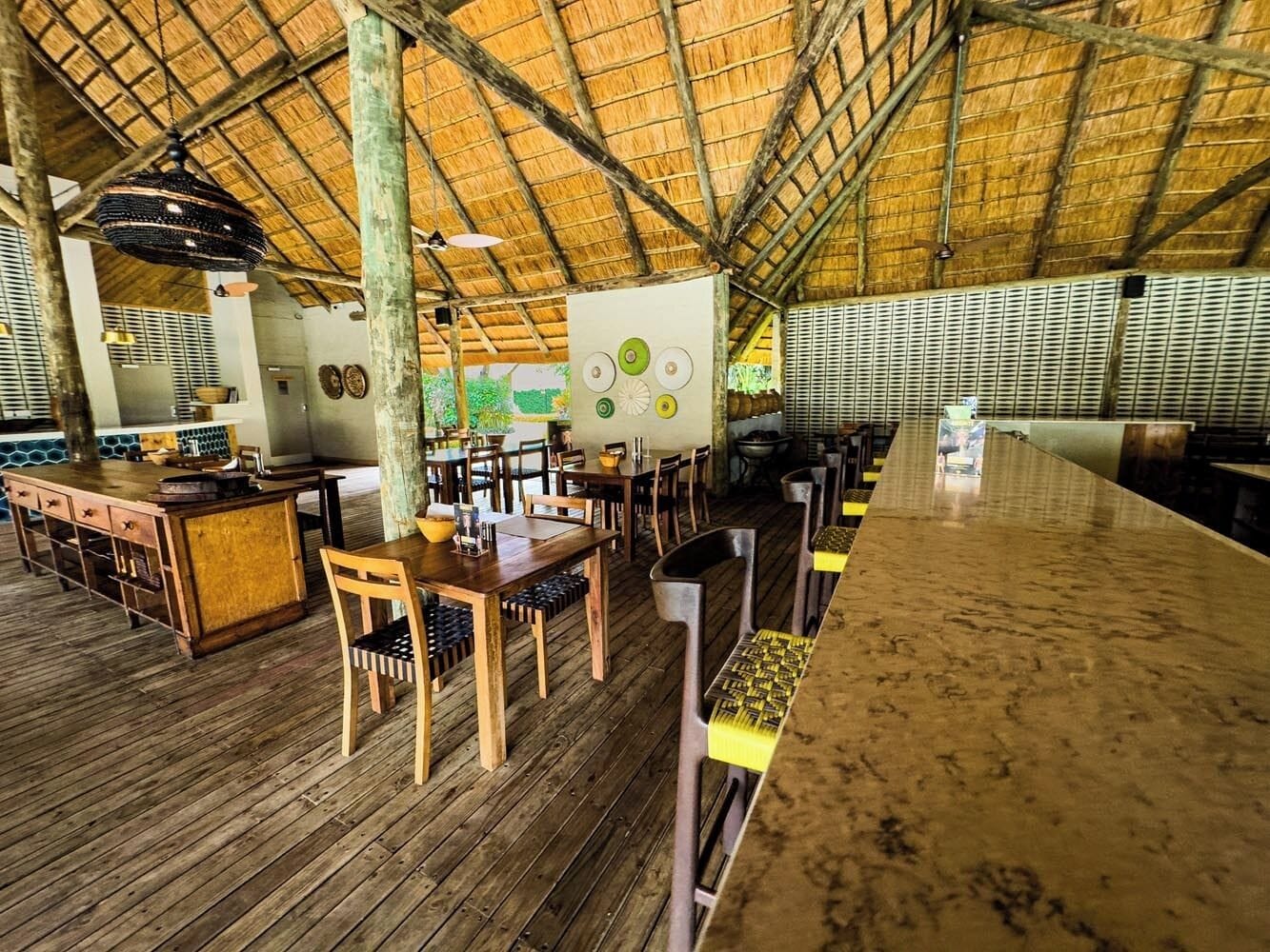 A rustic wooden interior with a high ceiling and a bar area.