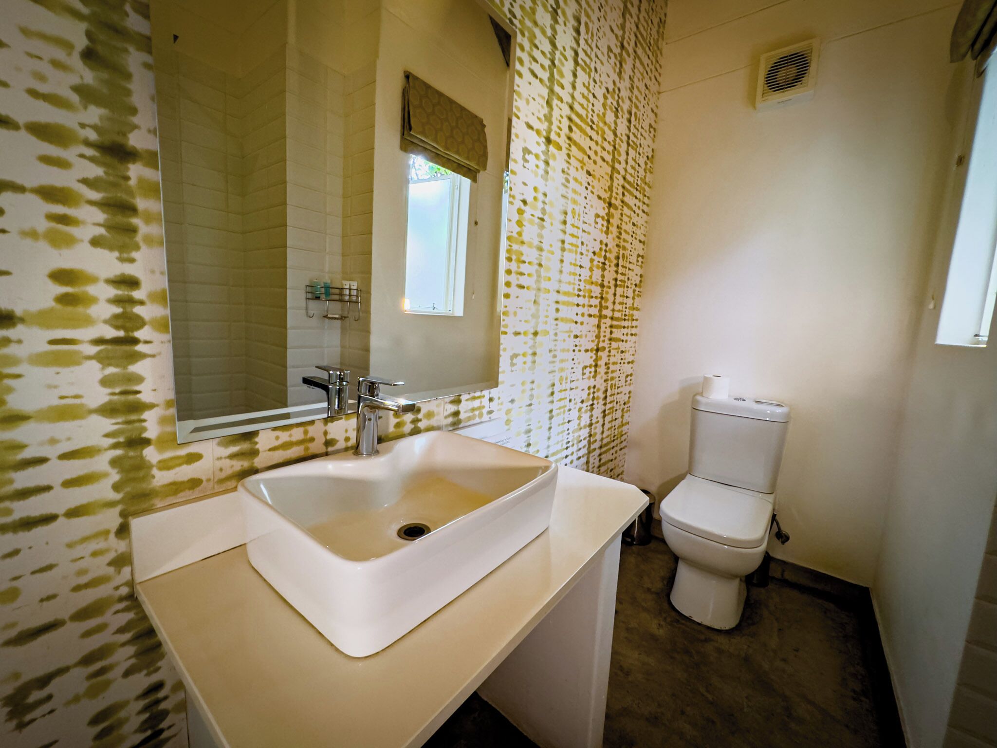 A bathroom with a white sink, a toilet, and a shower curtain.