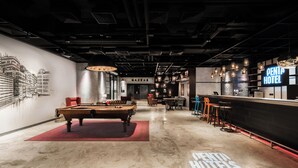 A modern hotel lobby with a pool table, bar area, and a mural of buildings. - Pentahotel Hong Kong, Tuen Mun (Tuen Mun)