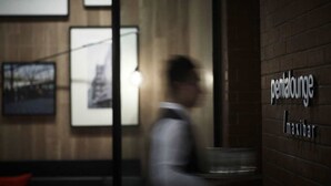 Interior borroso de un edificio con un cartel que dice 'penal lounge' y 'maxibar'.