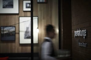 A blurred interior of a building with a sign reading "penal lounge" and "maxibar".