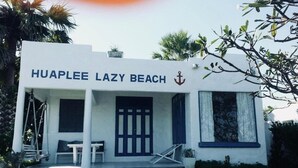 Un edificio blanco con el letrero "HUAPLEE LAZY BEACH" y un símbolo de ancla.