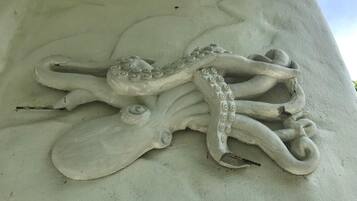 Eine Skulptur eines Oktopus auf einem Betonpfeiler.
