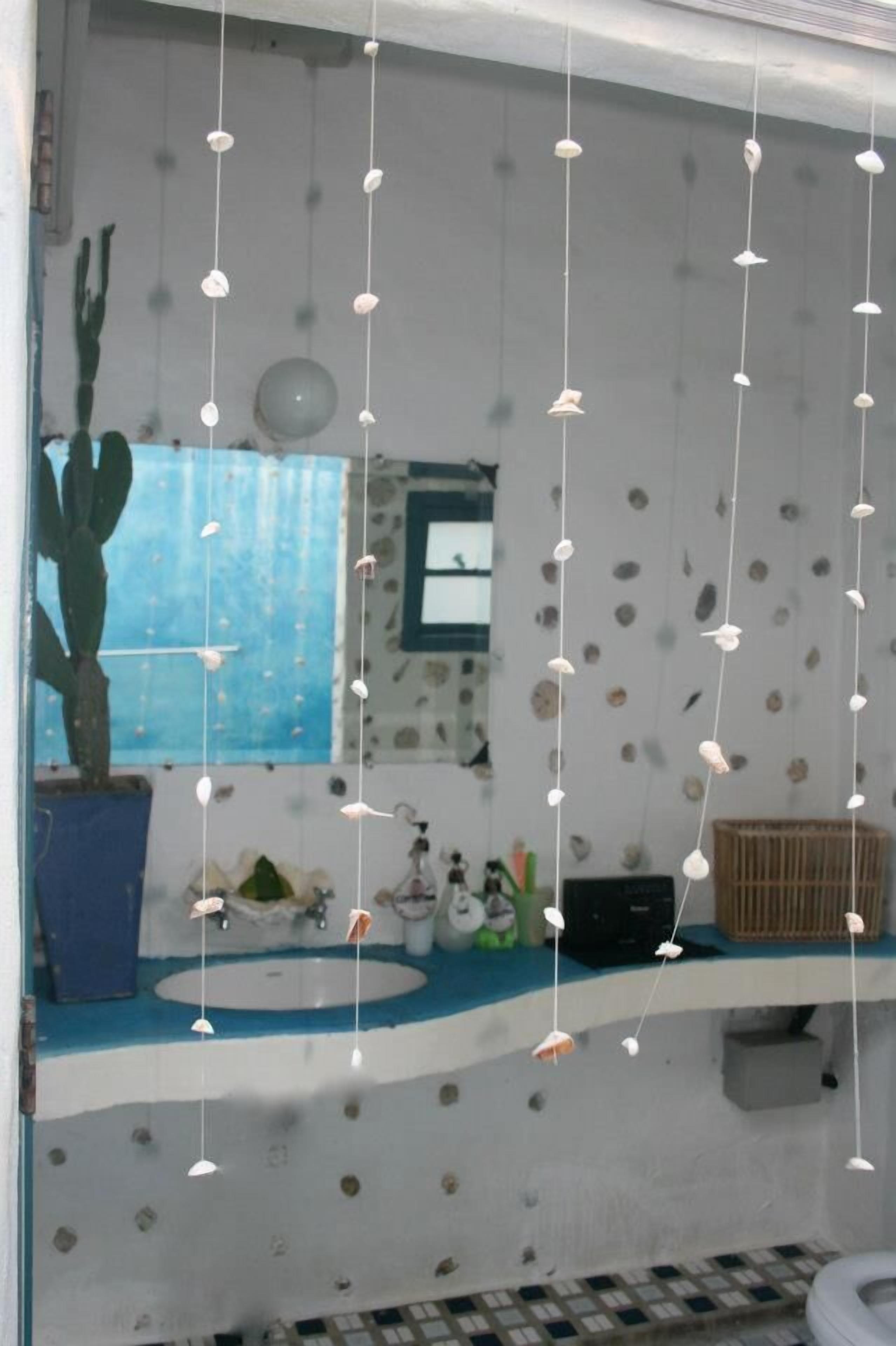Ein Badezimmer mit Waschbecken, einer Topfpflanze und einem Fenster mit Blick.