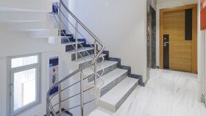 A modern interior with a staircase, an exit sign, and a wooden door. - Nishant Boutique Hotels (Istanbul)