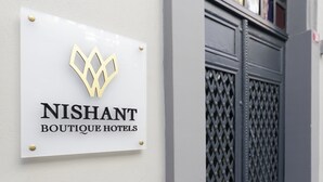 A sign for NISHANT BOUTIQUE HOTELS with a geometric logo. - Nishant Boutique Hotels (Istanbul)