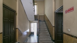 Un escalier dans un immeuble, avec un panneau indiquant qu'il est interdit de fumer.