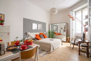 Una habitación de hotel moderna con cama, mesita de noche y zona de comedor.