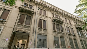 Un bâtiment historique doté de grandes fenêtres et d’une entrée centrale.