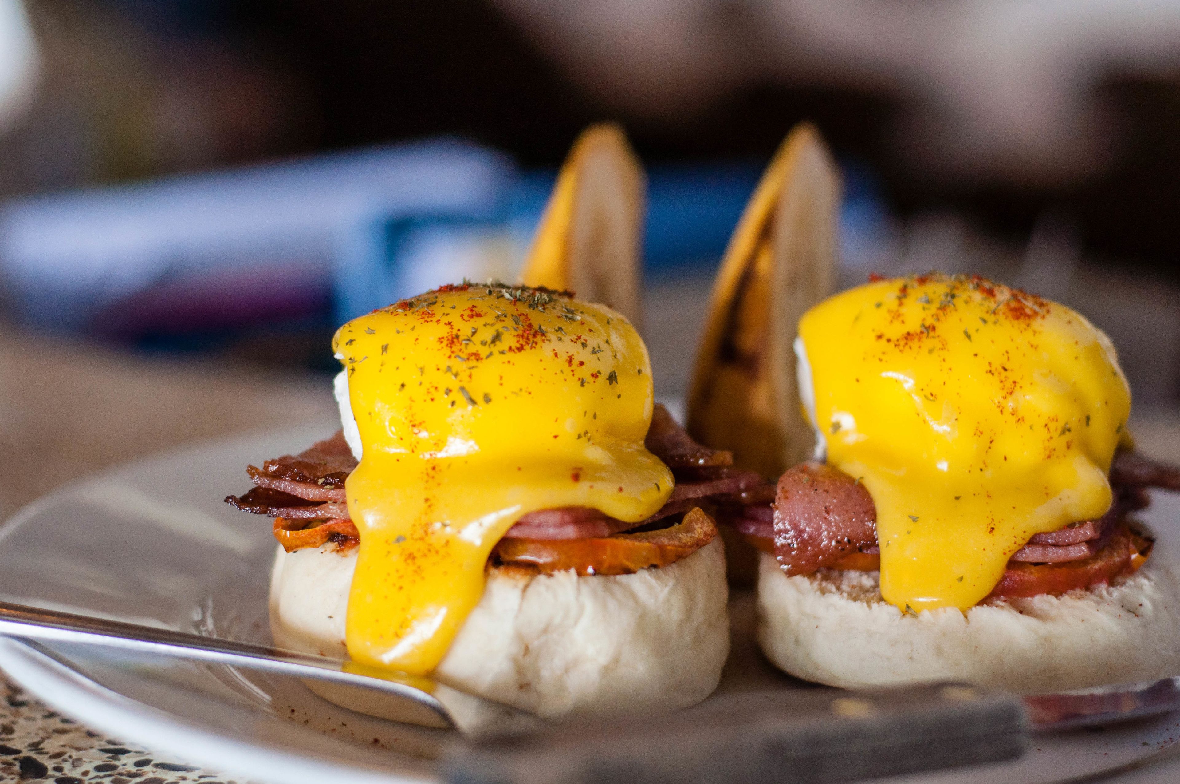 Dos sándwiches huevos benedictinos en un plato.