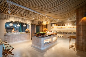 A modern kitchen with a central island, hanging baskets, and a tiled backsplash. - Zand Morada Pattaya (Pattaya)