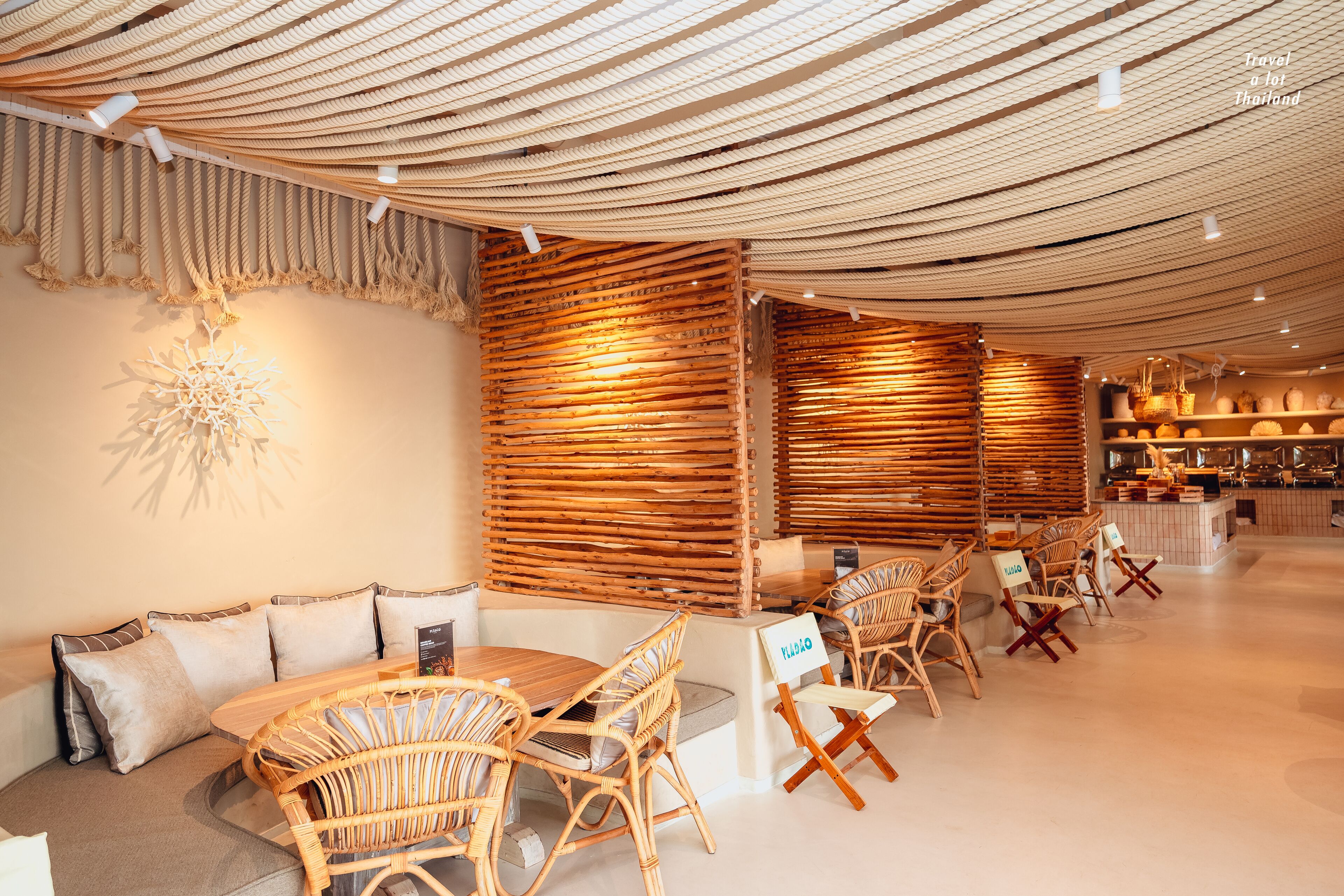 A modern interior with a wooden slatted wall, wicker furniture, and a ceiling with a woven design.