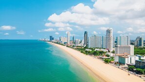 Un paisaje urbano costero con una extensa playa de arena y edificios altos.