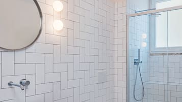 Une salle de bain moderne avec un lavabo rectangulaire, deux toilettes et une douche à parois de verre.